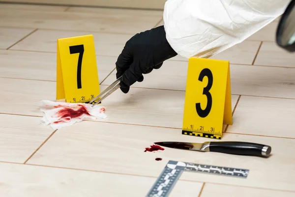 En kriminologi expert tittar igenom ett förstoringsglas på en blod — Stockfoto