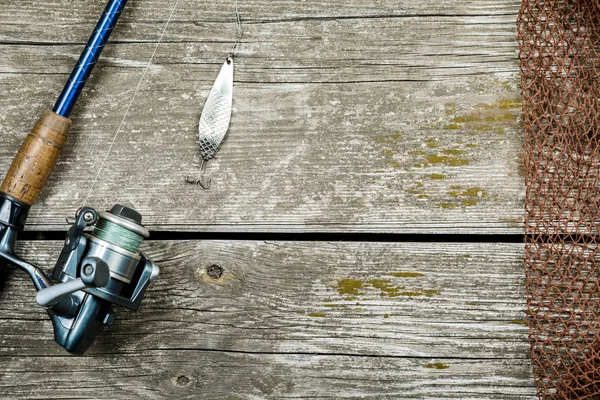 Equipamento de pesca, ganchos e iscas em um fundo de madeira — Fotografia de Stock