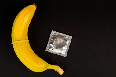 Siyah arka planda kondom ve muz yakın plan