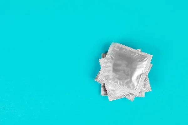 Preservativo sobre fundo azul. O conceito de sexo seguro. — Fotografia de Stock
