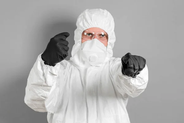 A medical scientist or a police officer in riot gear pointing to