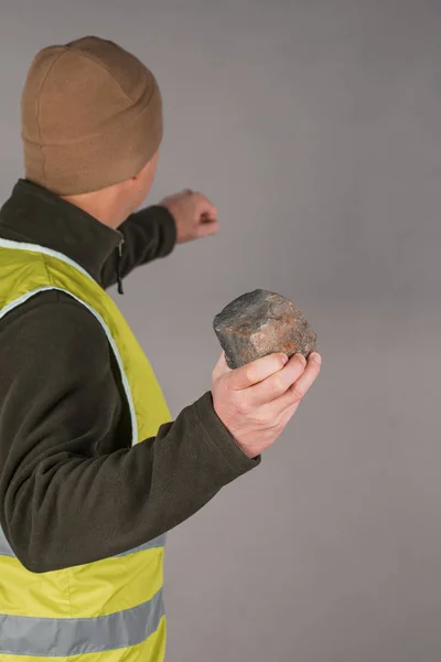 Rebel or protesting worker in a yellow vest with a brick in his — Stock Photo, Image