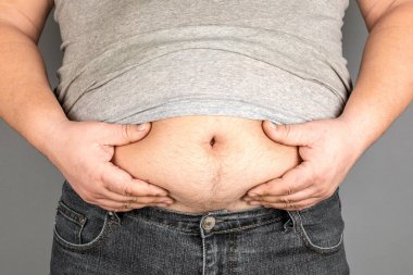 şişman adam, onun ağırlığı kontrol, gri bir arka plan üzerinde