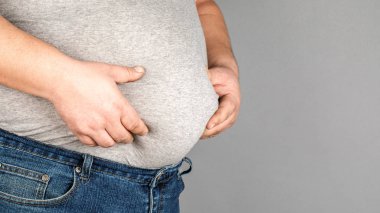 şişman adam, onun ağırlığı kontrol, gri bir arka plan üzerinde