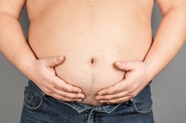 şişman adam, onun ağırlığı kontrol, gri bir arka plan üzerinde