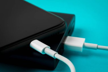 Mavi backgr üzerinde Usb kablosu üzerinden Power Bank ile şarj akıllı telefon