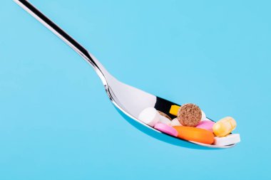 mavi arka plan üzerinde izole kaşık tablet çok