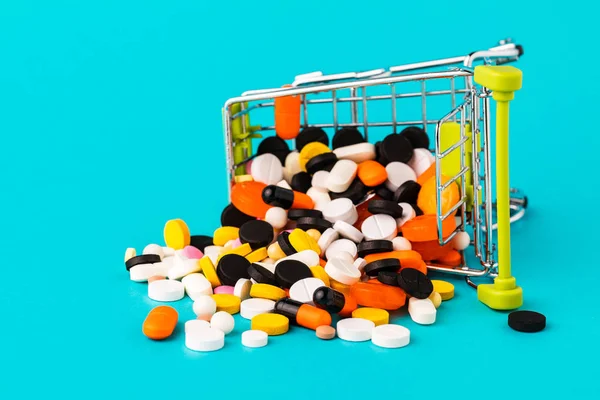 Shopping cart filled with pills. Blue background. Concept: full