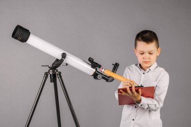 genç astronom bir teleskop ile bakar ve sekmesinde yazıyor