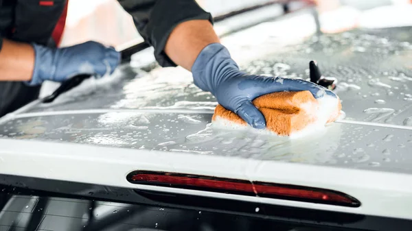 Człowiek myje mydłem biały samochód. Czyszczenie koncepcja — Zdjęcie stockowe