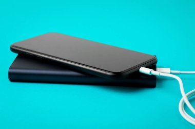 Mavi backgr üzerinde Usb kablosu üzerinden Power Bank ile şarj akıllı telefon