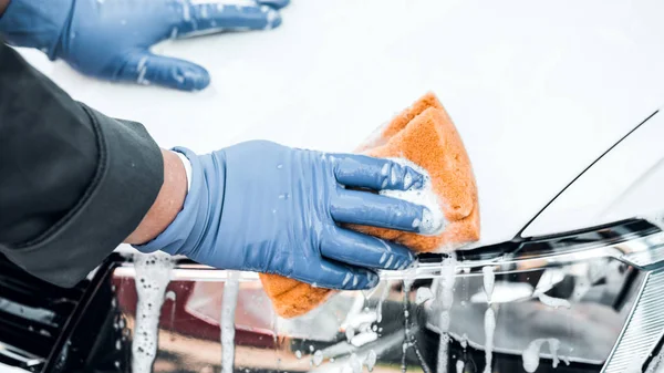 Bir adam bir sabun beyaz araba yıkar. Temizlik kavramı