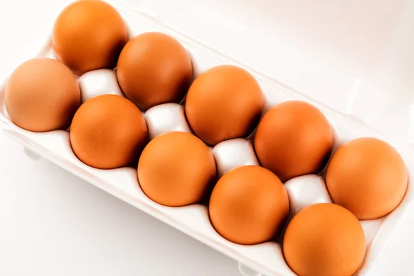 Ovos castanhos em embalagem de plástico sobre fundo branco . — Fotografia de Stock