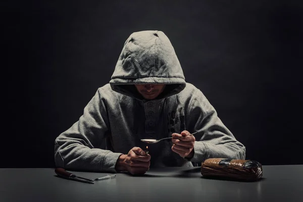 Primer plano de un hombre preparando drogas con un encendedor. El concepto de — Foto de Stock