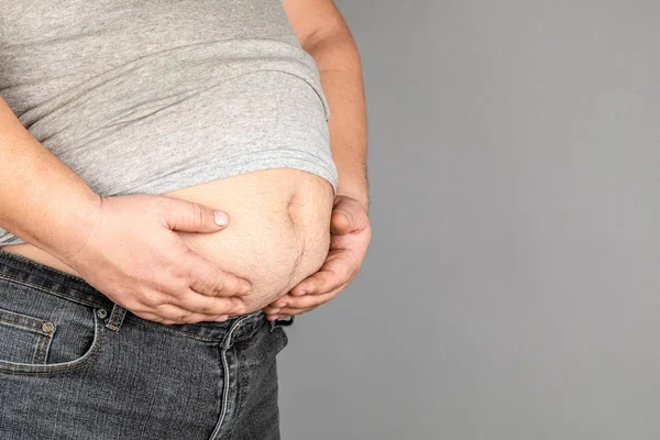 Dicker Mann, sein Gewicht prüfend, auf grauem Hintergrund — Stockfoto