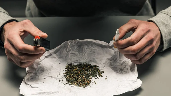 Drogově závislý dělá cigaretu s marihuanou. Koncept d — Stock fotografie