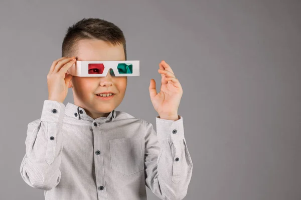 Young handsome boy with 3d glasses on grey background in Studio.