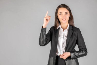 kız gri bir arka plan üzerinde bir şey gösterir. yaşam tarzı ve insanlar 