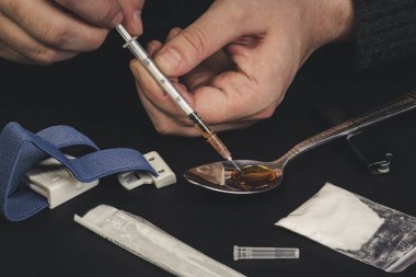 Kötü adam. Şırıngalı bir uyuşturucu bağımlısı uyuşturucu üretir ve kullanır