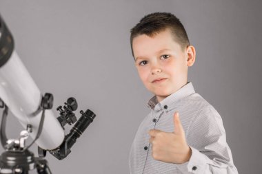 Genç astronom çocuk teleskoptan bakıyor..