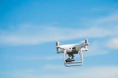 Mavi gökyüzü arka planında dijital kamerası olan drone kuadkopteri.