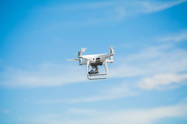 Mavi gökyüzü arka planında dijital kamerası olan drone kuadkopteri.