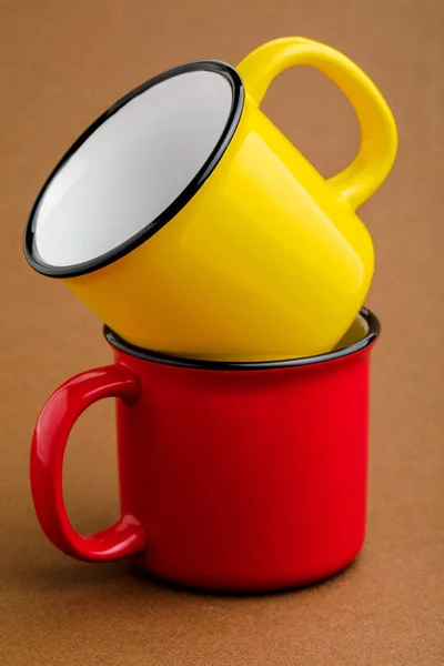 Red and yellow mug, on brown background.