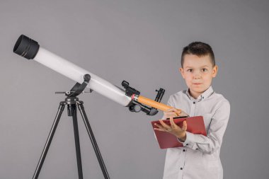 genç astronom bir teleskop ile bakar ve sekmesinde yazıyor