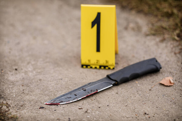 Расследование места преступления, окровавленный нож с маркерами преступлений на й
