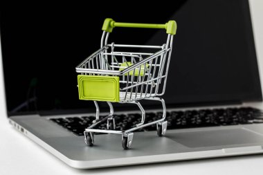 Online alışveriş ve e-Ticaret. Sepet ve dizüstü bilgisayar beyaz backg üzerinde