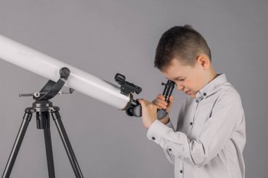 genç astronom bir teleskop ile bakar ve sekmesinde yazıyor