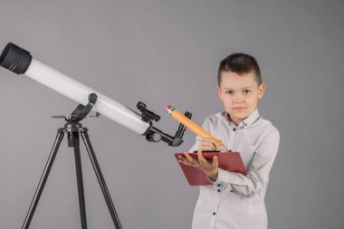 genç astronom bir teleskop ile bakar ve sekmesinde yazıyor