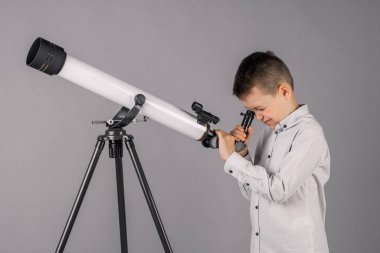genç astronom bir teleskop ile bakar ve sekmesinde yazıyor