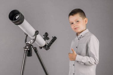 Genç astronom çocuk teleskoptan bakıyor..