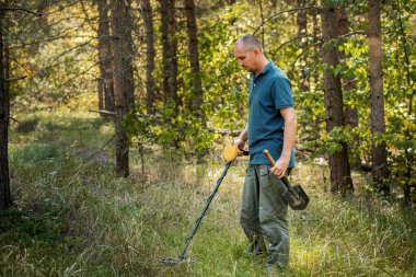 Elektronik metal dedektör ütülcü, açık arka planlı adam.