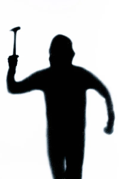 Ein gefährlicher Mann hinter Milchglas mit Schläger und Hammer — Stockfoto