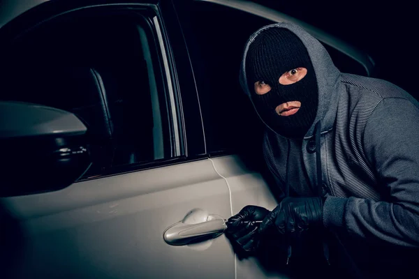 Un homme avec une cagoule sur la tête a essayé de s'introduire dans la voiture. . — Photo