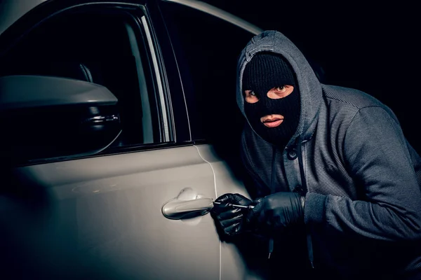 En man med en Balaclava på huvudet försökte bryta sig in i bilen.. — Stockfoto