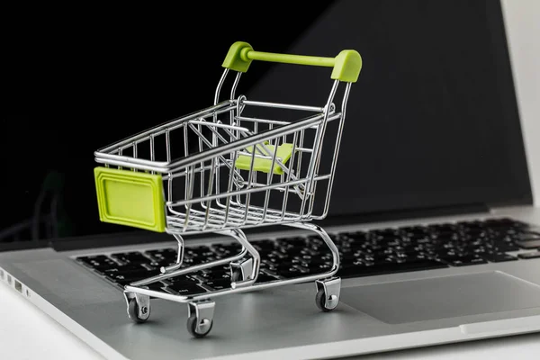 Compras en línea y comercio electrónico. Cesta y portátil en respaldo blanco — Foto de Stock