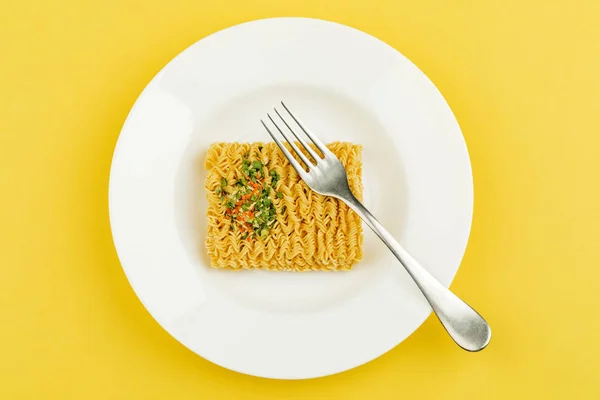 Un plato de fideos sobre un fondo amarillo. Vista superior . —  Fotos de Stock