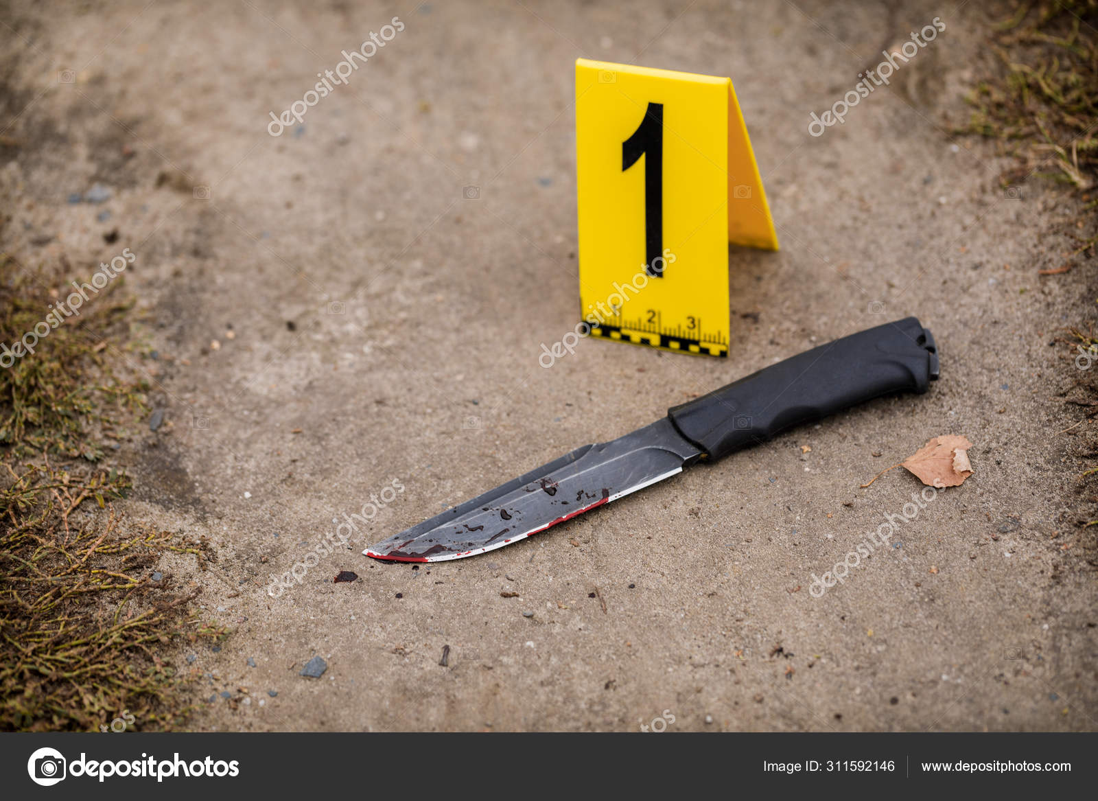 Crime scene investigation, bloody knife with crime markers on th
