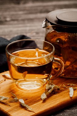 Ahşap masa üzerinde ıhlamur ile çay cam fincan.