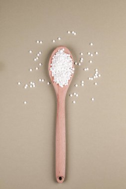 Kahverengi bir arka plan üzerinde tahta bir kaşık üzerinde şeker yerine tabletler