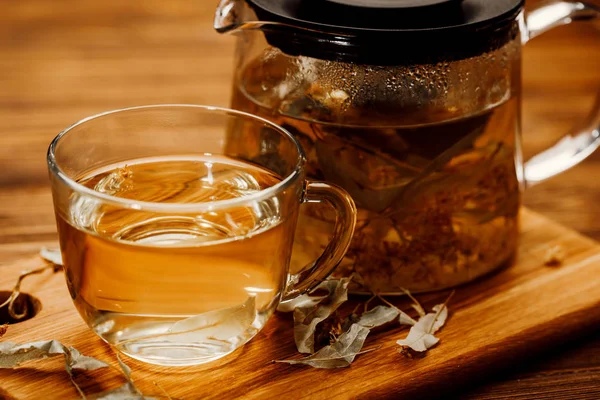 Coupe de thé en verre avec tilleul sur table en bois . — Photo