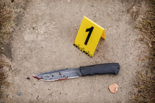 Crime scene investigation, bloody knife with crime markers on th — Stock Photo, Image