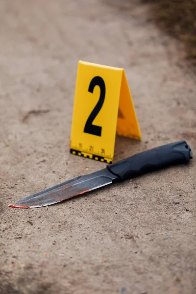 Crime scene investigation, bloody knife with crime markers on th — Stock Photo, Image