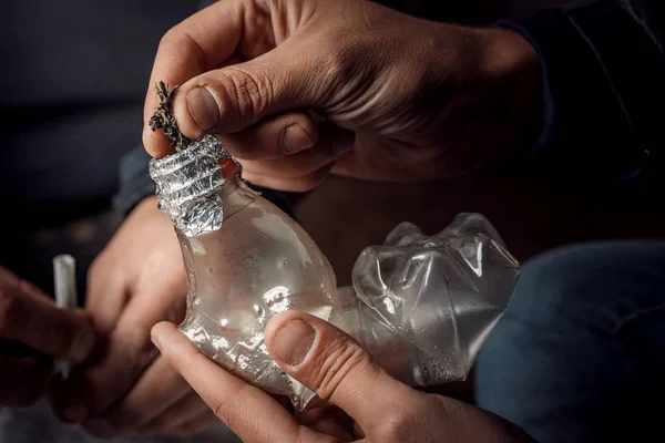 Een man rookt drugs door middel van een bong fles, een manier om cannabi te gebruiken — Stockfoto