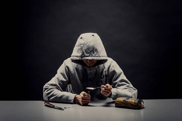 Primer plano de un hombre preparando drogas con un encendedor. El concepto de — Foto de Stock