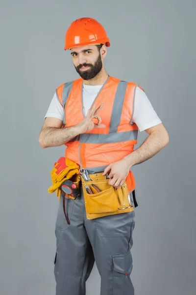 Studioporträt eines Bauunternehmers, auf grauem Hintergrund — Stockfoto