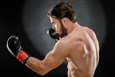 Boks eldivenli bir adam. Siyah arka planda boks yapan bir adam. Sağlıklı yaşam tarzı kavramı.